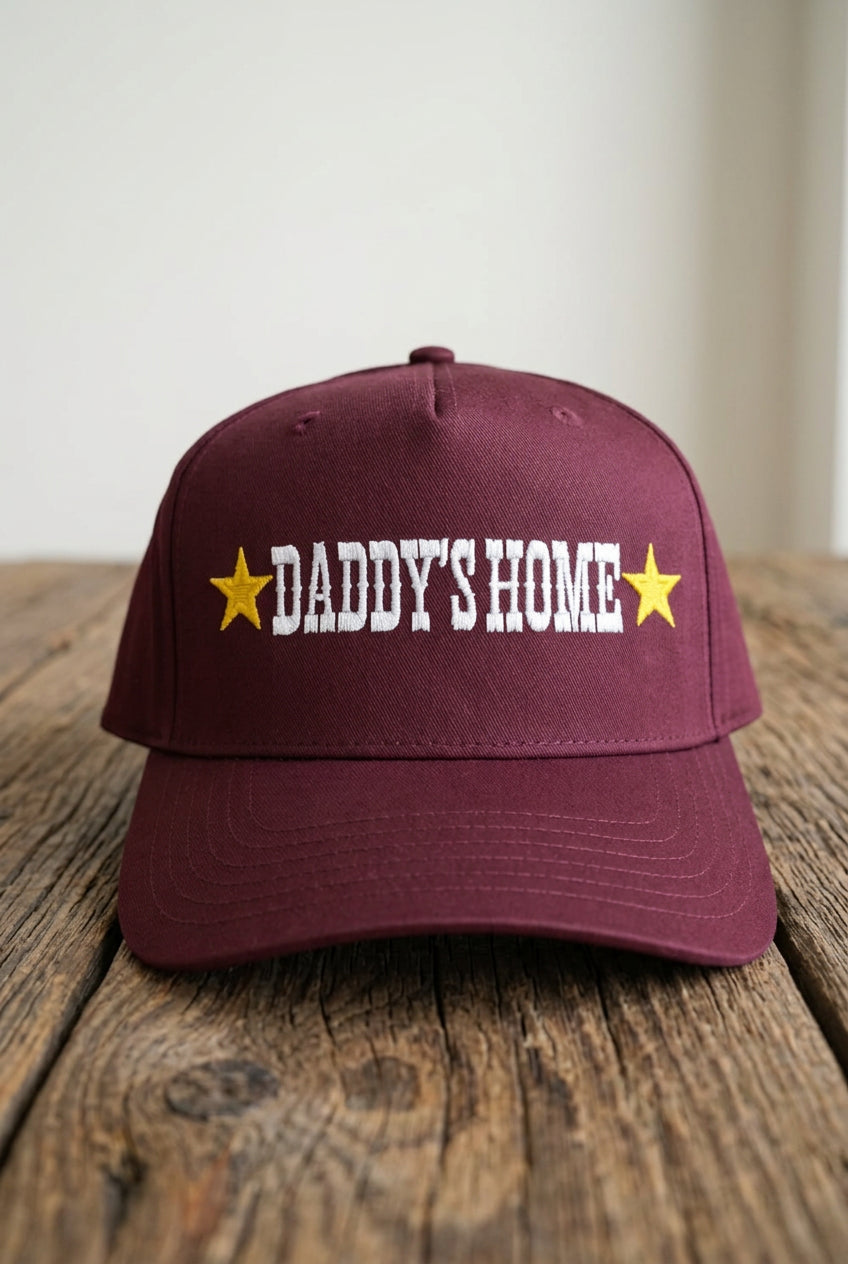 DADDY'S HOME Embroidered Burgundy Trucker, front view on a rustic wooden table