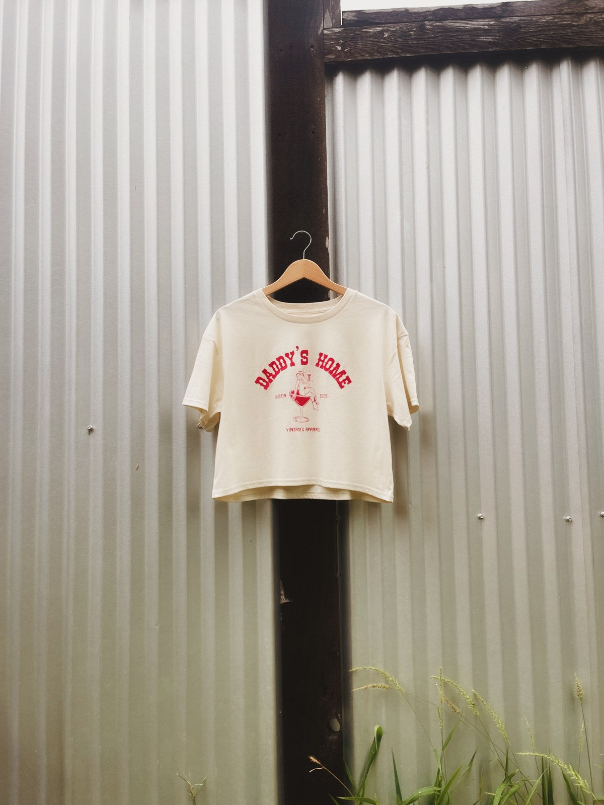 The Cropped Martini Logo Tee held up outdoors