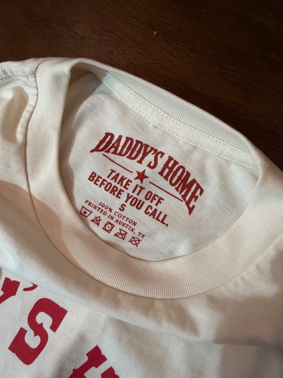 Close-up of the Daddy's Home printed neck tag, 100% cotton, printed in Austin TX